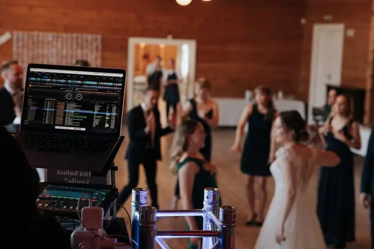 dj soittaa hääjuhlassa, ihmiset tanssivat, myös morsian