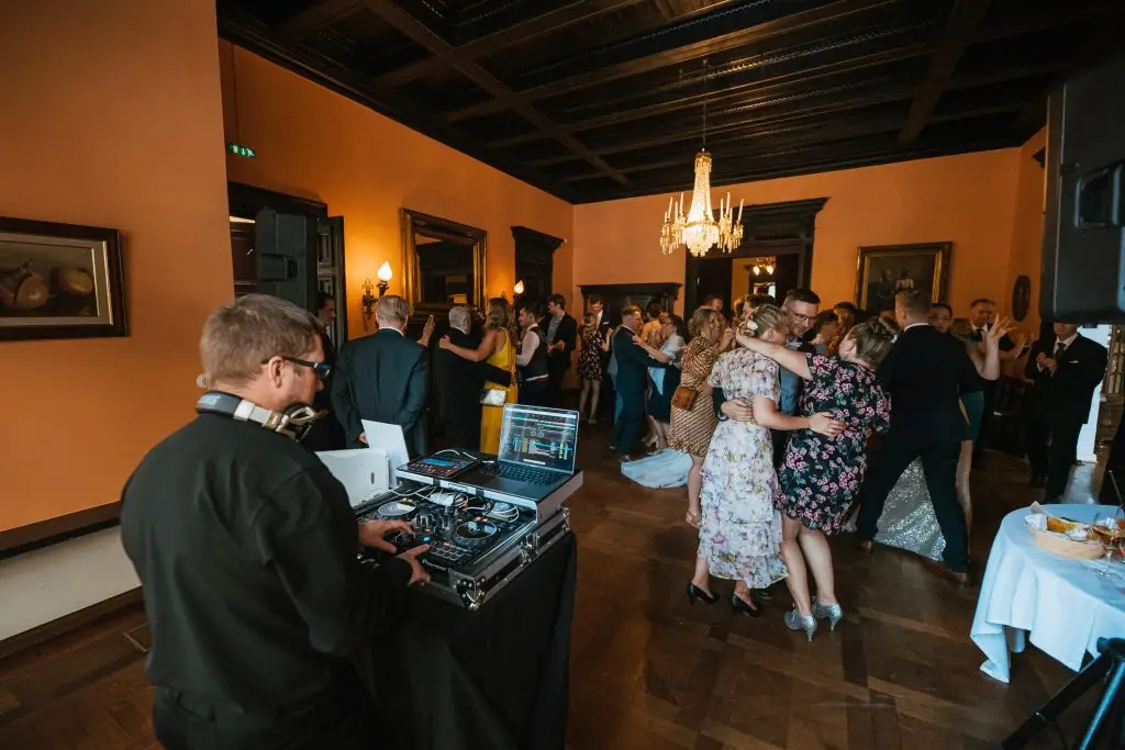 Hääjuhlassa ihmiset tanssivat, hyvä tunnelma, dj soittaa musiikkia.